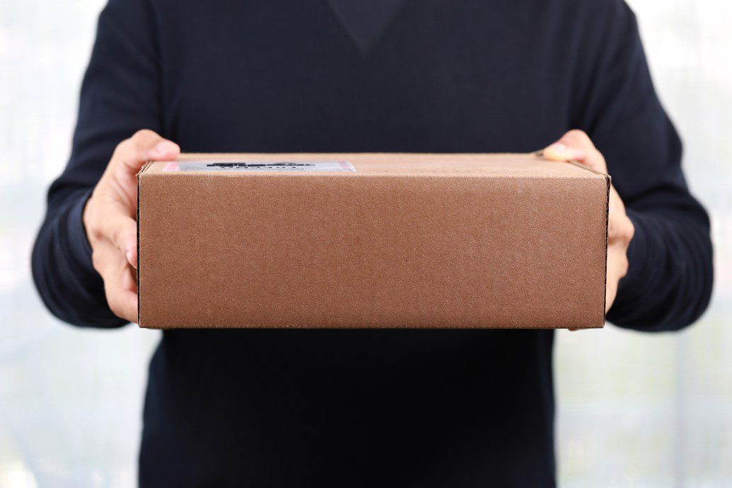 Closeup Hands of delivery man holding package